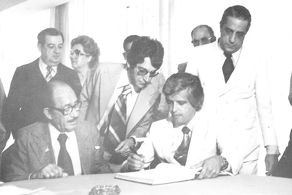 A foto de hoje nos leva de volta à época do surgimento do Grupo Novo, em fins dos anos 70, quando Maurício Ribeiro foi prefeito pela primeira vez. O flagrante registra o ato de assinatura de algum convênio, com o representante, de óculos, que o próprio Ma